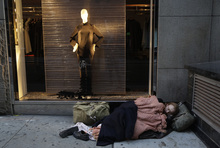   FILE - In this Wednesday, Nov. 20, 2013, file photo, a destitute man sleeps on the sidewalk under a holiday window at Blanc de Chine, in New York  The growing gap between the richest Americans and everyone else isn't bad just for individuals it's hurting the U.S. economy says a majority of more than three dozen economists surveyed in December 2013 by The Associated Press. (AP Photo/Mark Lennihan, File)  