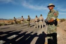   Federal law enforcement officers block a road at the Lake Mead National Recreation Area near Overton, Nev. April 10, 2014. In the foreground are the shadows of people protesting the Bureau of Land Management roundup of cattle owned by Cliven Bundy.  Former BLM director Bob Abbey says Bundy supporters who threatened BLM employees during the roundup should be held accountable. (AP Photo/Las Vegas Review-Journal, John Locher)  