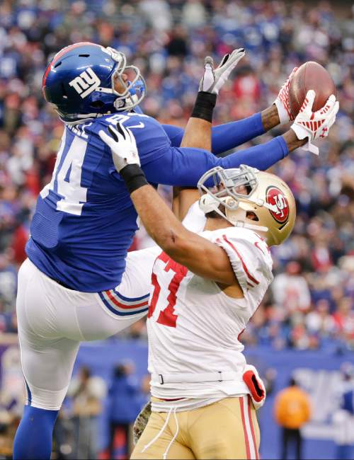 New York Giants tight end Larry Donnell (84) catches a pass over San Francisco 49ers inside linebacker Michael Wilhoite (57) during the first half of an NFL football game Sunday, Nov. 16, 2014, in East Rutherford, N.J.  (AP Photo/Julio Cortez)