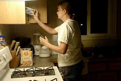 Wearing her husband's T-shirt and pajama pants because they still hold Brad's scent, Sandra Triplett makes tea in Enoch.; 6:08 a.m. Utah; 4:08 p.m. Iraq