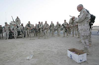 Assistant Chaplan Edward Hoyum leads a group of soldiers in prayer before they leave in a convoy to Fallujah. For many soldiers, balancing God with military responsibility is a war unto itself.