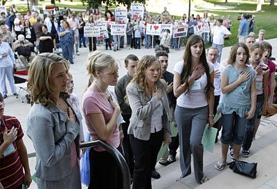 Speakers at the pro-polygamy rally lead the audience Saturday in the Pledge of Allegiance at the Salt Lake City-County Building.
