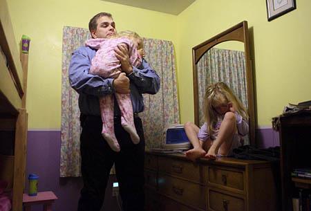 Within weeks of returning from Iraq, Joe Lappi was granted primary custody of his four children. On a recent Tuesday morning, he cradles 3-year-old Lillian as 6-year-old Daria fights to wake up.