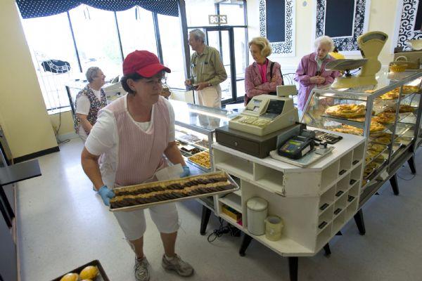 After 34 years in business, Leslie's Bakery has moved down the street to a new home. The popular Holladay bakery had to relocate as part of construction that is happening on the Holladay Village Center.  Old customer return to the new location at 2308 Murray-Holladay Road  Friday morning.   Kim Leslie, left, stocks the display cases Friday morning.     Al Hartmann/The Salt Lake Tribune   5/22/09