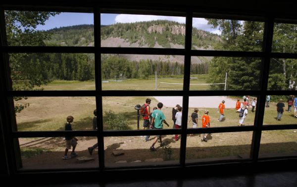 Camp Roger-  Campers are framed in a giant picture window in the main lodge of Camp Roger, near Kamas, as they head to the volleyball court Wednesday Jul 22, 2009.  Steve Griffin/The Salt Lake Tribune 7/22/09