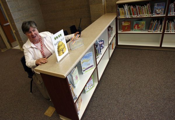 West Valley City - Diamond Ridge Elementary principal Debbie Koji jokes about the reference vantage point as she sits where a counter top and reference computers will soon go in the new library.  Diamond Ridge Elementary which was just built in the Diamond Summit subdivision of West Valley City opened its doors to 637 new students while contruction crews finished up a few minor projects.  Photo by Francisco Kjolseth/The Salt Lake Tribune 8/26/2009