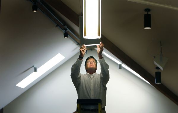 Steve Biesanz, of Winona Lighting, on Monday adjusts one of the light fixtures that his company installed in the remodeled sanctuary at St. Therese of the Child Jesus Catholic Church in Midvale. The church suffered a fire two years ago and has undergone a remodeling. The reopening is Sunday.