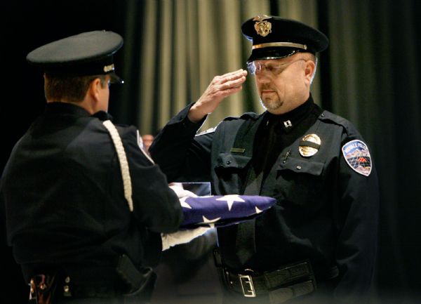 Scott Sommerdorf  |  Salt Lake Tribune
KODA
Midvale Police Captain Steve Shreeve (right) salutes as he is presented with the flag that covered 