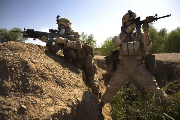 U.S. Marines, Corman Michael Lang, of Camden County, Georgia, right, and Lance Cpl. Ard Bizahaloni of Pinon, Arizona, with the First Battalion, Sixth Marine Regiment, Alpha company, take up positions as they are involved in a gunbattle during a patrol in Marjah, Afghanistan, Friday, March 19, 2010. (AP Photo/Dusan Vranic)