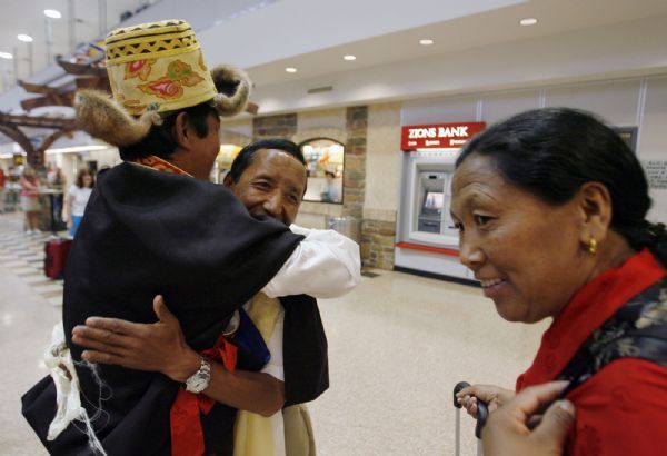 Salt Lake City - Apa Sherpa, center, gets a big hug from, Kami, a relative, after his wife, Yangji, right, greeted him as he returns from Nepal where he successfully added to his world record for climbing Mt. Everest with his 19th summit. He was met at the Salt Lake International Airport by his family and friends.  Friday May 29, 2009.  Steve Griffin/The Salt Lake Tribune 5/29/09