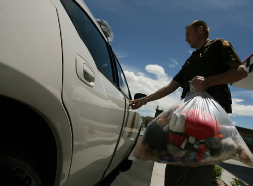 Utah Highway Patrol officer Taylor Van Houten carries one of four bags of stuffed animals to his car to hand out to other Davis County UHP officers. Ethan Stacy Memorial Teddy Bear and Fund on Saturday collected stuffed animals for police and fire and rescue to carry in their vehicles to give to children in times of distress. The group is doing it to honor Ethan's memory.  Leah Hogsten  |  The Salt Lake Tribune