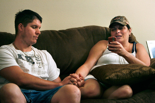 Carla Jones reads a text about Stephanie Stacy sent by one of Jones' friends as her husband Kenny Jones holds her hand in their Sanford, Fla., Saturday, May 22, 2010. Scott Sommerdorf  |  Salt Lake Tribune
