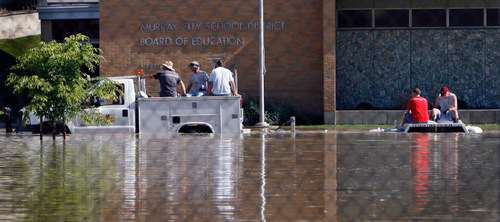 Steve Griffin  |  The Salt Lake Tribune&#xA;&#xA;Murray City workers make their way through a flooded parking lot at State Street near 5100 south Monday, June 7, 2010, as water from little Cottonwood Creek jumped its banks in Murray Park flooding the park and surrounding parking lots at businesses and city buildings.