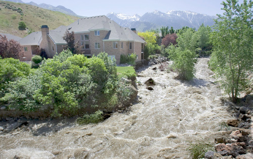 Steve Griffin  |  The Salt Lake Tribune&#xA;&#xA;The swollen Cottonwood Creek laps at the foundation of a home that is being threatened by high runoff water from the creek Monday, June 7, 2010. The previous evening crews worked through the night to shore up the ground, just to the right of the home, with giant boulders. The creek jumped its banks and swept a portion of the homes yard away near 8900 South&#xA;and 3100 East  in Salt Lake County. The home's yard originally extended out to the tree that is in the middle of the creek.