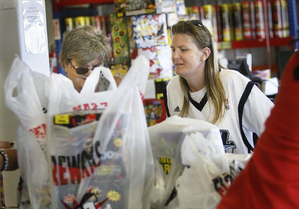 Scott Sommerdorf  l  The Salt Lake Tribune

Wearing her Utah Jazz jersey, Nicole Black (right) of Salt Lake City looks over her fireworks purchases in the TNT Fireworks store in Evanston,  Wyoming, Friday, July, 2, 2010.