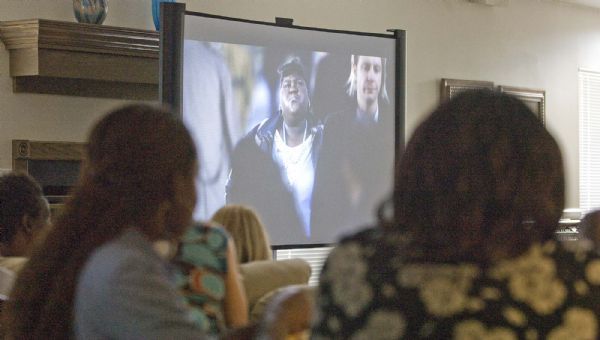 After a meal of catfish, coleslaw and baked beans, a group of people, invited by the Rev. Nurjhan Govan of Trinity African Methodist Episcopal Church view the movie 