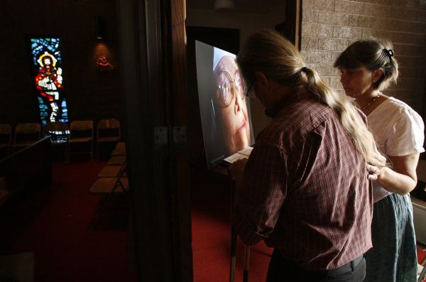 Leah Hogsten  |  The Salt Lake Tribune
Steve and Donna Bryant sign the guest list at the entrance to the monastery chapel. Funeral services for   Sister Mary Joseph (Barbara) Whipperman at the Carmelite Monastery Chapel on Saturday July, 17, 2010. Sister Mary Joseph (Barbara) Whipperman, 77, died July 13, 2010 in Holladay, Utah. Born May 11, 1933, Salt Lake City, Utah, to Ernest and Edna Duncombe Whipperman. Raised in the LDS faith, she worked as a nurse's aide at LDS Hospital, and then enrolled in Brigham Young University's nursing program. She graduated with honors in 1956, beginning a career as a public health nurse in Salt Lake City. She entered the Carmelite Order in 1963.