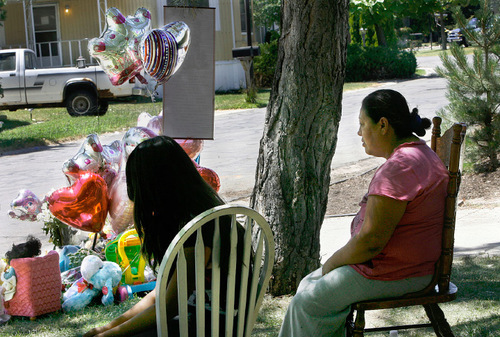Scott Sommerdorf  l  The Salt Lake Tribune
Maria Mesa, the grandmother of 1-year-old Vicsayra Maribel Garcia, sits in b silence near the roadside memorial for her granddaughter, who was killed in a hit-and-run incident Friday night. The incident occured outside her home in The Majestic Oaks subdivision of Taylorsville. Vicsayra's cousin Karen Serrano sits at left. The neighborhood is in mourning, and wants police to find the driver to see if she knew that she had hit Vicsayra.
