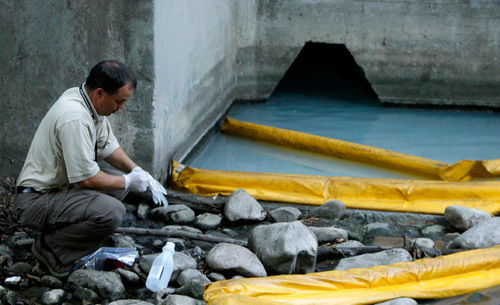 Salt Lake Valley Health Department environmental health specialist Jeremy Roberts takes samples of the water to test.  White latex paint flowed into City Creek via a storm drain from the Avenues, fire crews said. The storm drain has been dammed to prevent further contamination.
Leah Hogsten  |  The Salt Lake Tribune