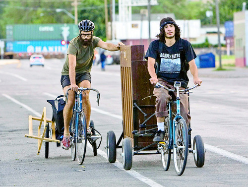 Steve Griffin  |  The Salt Lake Tribune

Corbin Baldwin, right, pulls as Eric Rich pushes their upright grand piano from their bikes on their way to perform at the farmer's market in Salt Lake City on Saturday, August 7, 2010. The 