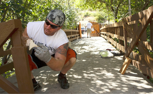 Leah Hogsten  |  The Salt Lake Tribune&#xA;Tesoro employee Todd Parry paints the newly reconstructed bridge into Camp Kostopulos. More than 120 employees from Tesoro and the LDS Church painted, trimmed, installed, mulched, pruned and planted  at Camp Kostopulos in Salt Lake City on Wednesday, Sept. 8, 2010.  The effort was part of United Way's massive day of volunteering.