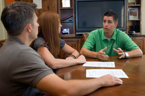Al Hartmann  |  The Salt Lake Tribune&#xA;Chad, left, and Rachel Lingmann discuss refinancing options with Brady Johnson of RANLife Home Loans. They swapped their 30-year mortgage at 5.875 percent for a 20-year term at 4.375 percent. 