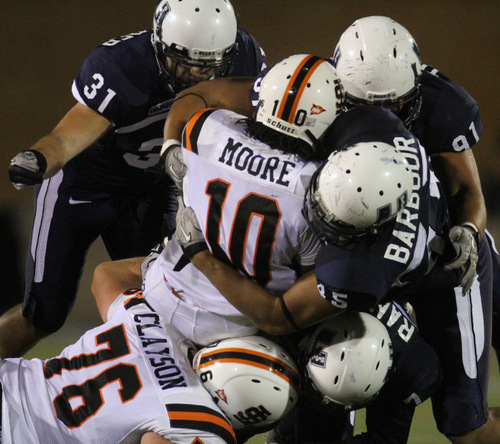 Rick Egan   |  The Salt Lake Tribune&#xA;&#xA;It takes four aggie defenders to bring down Tavoy Moore, Idaho State, in football action,  Utah State vs. Idaho State football game, Saturday, September 11, 2010.  76 is Braeden Clayson