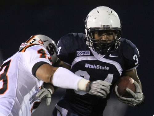 Rick Egan   |  The Salt Lake Tribune&#xA;&#xA;Michael Smith (34) runs the ball for the Aggies , as Leki Fuapau (34) Idaho State,  defends, in football action,  Utah State vs. Idaho State football game, Saturday, September 11, 2010.