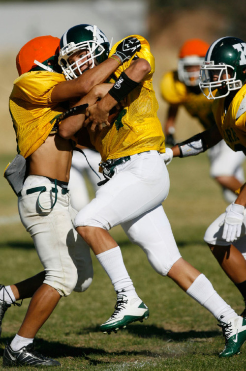 Francisco Kjolseth  |  The Salt Lake Tribune&#xA;Kearns quarter back Justin Summers tries to push through the defensive line as the young Kearns team, led by quarterback J.R. Finai, are off to another solid start as the team practices on their field in Kearns.&#xA;Kearns, Sept. 13, 2010.