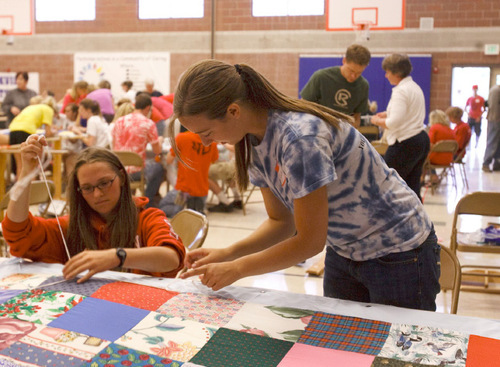 Leah Hogsten  |  The Salt Lake Tribune &#xA;Volunteers Laura Tatham, 18, and Kathryn Whipple, 18, students at the University of Utah, piece together a quilt to give to refugees in foreign countries. The Bennion Center volunteers participated in the center's seventh annual day of service at Parkview Elementary on Saturday.