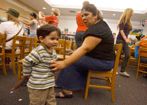 Leah Hogsten  |  The Salt Lake Tribune &#xA;Maria Hernandez plays and growls like a dinosaur at her son, Aaron Galan, 2, after finishing reading a book about dinosaurs. The Bennion Center volunteers gave books to children, knitted caps for newborns at Primary Children's Hospital and made quilts for refugees during its 7th annual day of service at Parkview Elementary, Saurday, September 18, 2010, in Salt Lake City.