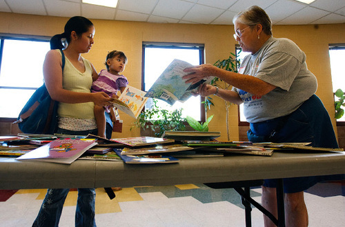 Leah Hogsten  |  The Salt Lake Tribune &#xA;Maria Vieyra and her daughter Cynthia Robles, 1-year, receive help picking out books by Bennion Center volunteer Libby Hunter (right). The Bennion Center volunteers gave books to children, knitted caps for newborns at Primary Children's Hospital and made quilts for refugees during its 7th annual day of service at Parkview Elementary, Saurday, September 18, 2010, in Salt Lake City.