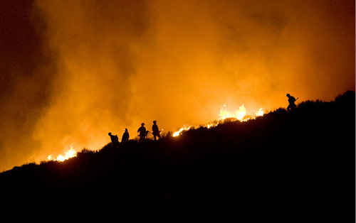 Djamila Grossman  |  The Salt Lake Tribune

Firefighters are seen on a ridgeline where a wildfire burns above Herriman, Sept. 19, 2010.  People throughout the area were evacuated and some houses burned down.