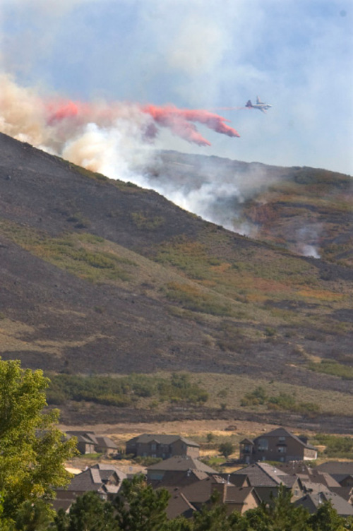 Al Hartmann  |  Salt Lake Tribune&#xA;Air tanker dumps flame retardent on fire that appeared about 2:30 p.m. Monday afternoon a little further west of the main burn near Rose Canyon Road in Herriman.