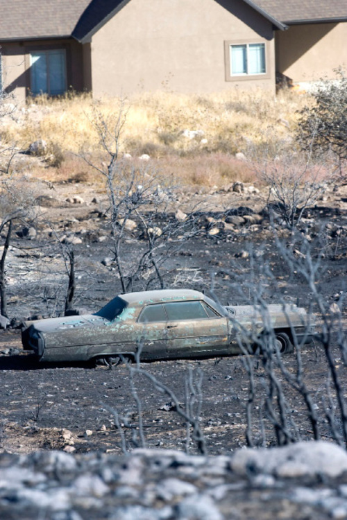 Al Hartmann  |  The Salt Lake Tribune
Burned out classic car on  the property of the Burns residence in Herriman on Tuesday Sept. 21.    It was one of three properties burned in the fire.  A few feet to the north a house stands untouched by the fire.