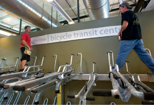 Al Hartmann  |  The Salt Lake Tribune&#xA;Canyon Sports has partnered with the city and UTA to open a bike rental and bike storage shop inside the transit hub at 250 S. 600 West.    Jeremiah Hansen, left, and Tyson Finch, of Desert Dogs Signs, put up a sign above  the bicycle storage racks on Thursday as the space is being finished.    There is a maintenance area for people to work on bikes and access to showers for commuters. Salt Lake City will open it to public on Saturday.