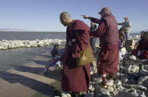 Kristen Moulton | The Salt Lake Tribune

Lama Konchog, of Crestone, Colo., points toward the Great Salt Lake on Monday as Tenzin Weigyal, a Buddhist monk, watches dry brine shrimp eggs float on the water along the causeway to Antelope Island. Members of a sangha in Salt Lake City, Katog Jnana Ling, dump cans of the egg into the water.