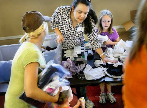 Scott Sommerdorf  l  The Salt Lake Tribune&#xA;Christine Gibbs and her 7-year-old daughter Maggie, right, helped hand out clothing to a homeless mother and daughter at St. Vincent De Paul's as they skipped church to participate in 