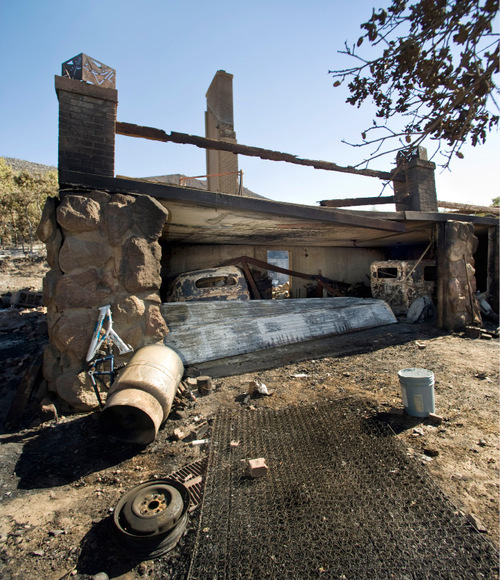 Antique automobiles lie in rubble of the Johnson home Monday, Sept. 20, 2010, in Herriman, Utah. (© 2010 Douglas C. Pizac/Special to The Tribune)&#xA;