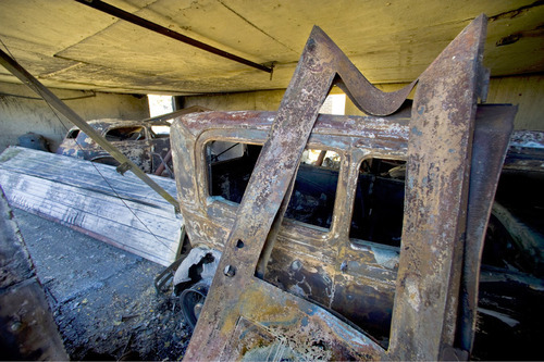 A 1938 Ford Coupe, right, and a 1936 Ford Coupe lie in rubble in the garage of the Johnson home Monday, Sept. 20, 2010, in Herriman, Utah. (© 2010 Douglas C. Pizac/Special to The Tribune)&#xA;