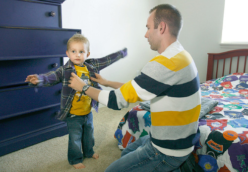 Scott Sommerdorf  l  The Salt Lake Tribune&#xA;Todd Call dresses his three year old son Spencer in Spoencer's bedroom in their new apartment at Florentine Villa, Thursday, September 23, 2010. Federal stimulus funds helped build Florentine Villa, a new low-income apartment complex. Todd Call is a young teacher who moved his family there a few months ago.
