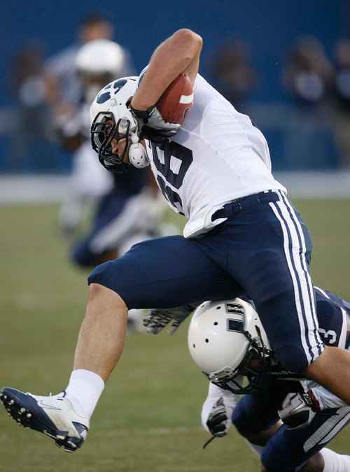 Trent Nelson  |  The Salt Lake Tribune&#xA;BYU tight end Austin Holt (88) is stopped by Utah State's Quinton Byrd. Utah State vs. BYU college football in Logan Friday, October 1, 2010.