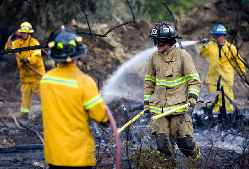 Djamila Grossman  |  The Salt Lake Tribune&#xA;&#xA;Firefighters spray down burnt trees and shrubs after a fire broke out at Wheeler Historic Farm in Murray, Sunday, Oct. 3, 2010.