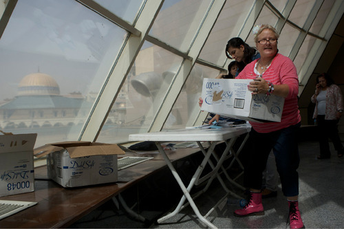 Colleen Parkin moves a box full of educational supplies at a conference center in Sulaimaniyah, Iraq. Parkin, whose son was killed in Iraq, as part of a delegation of 