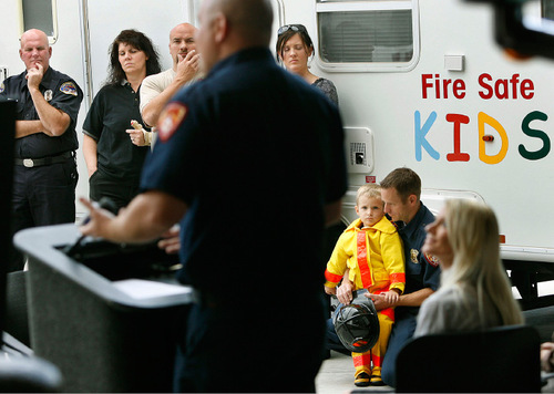 Scott Sommerdorf  l  The Salt Lake Tribune
As firefighter Ben Sharer speaks Monday, firefighter Jared Norton and his 4-year-old son Gavin listen in the crowd (second from right). The Juvenile Firesetters Intervention Program is a community outreach effort designed to help stop dangerous behaviors before they become a problem.  Jordan Tracy, 18, shared the story of how he was burned while playing with fire as a 15 year-old.