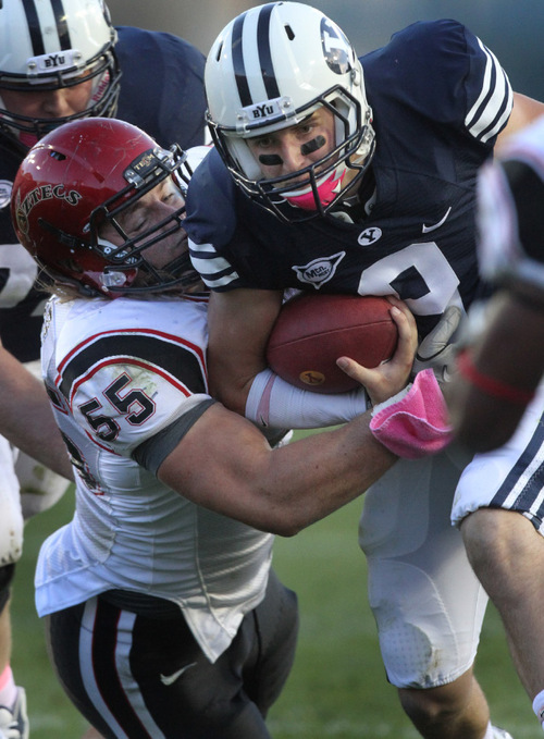 Rick Egan   |  The Salt Lake Tribune&#xA;&#xA;Jake Heaps, is brought down by Neil Spencer (55), in football action, BYU vs. San Diego State, at Lavell Edwards Stadium in Provo,  Saturday, October 9, 2010   Logan Ketchum  (31) defends for the Aztecs.