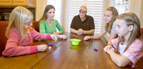 Paul Fraughton  |  The Salt Lake Tribune  &#xA;Nancy and Todd Pfortmiller play a dice game Thursday with their three children Heidi, 7, far left, Emma, 11, and Madeline, 9. The Pfortmillers are having trouble finding health insurance for their family because  of chronic health problems.