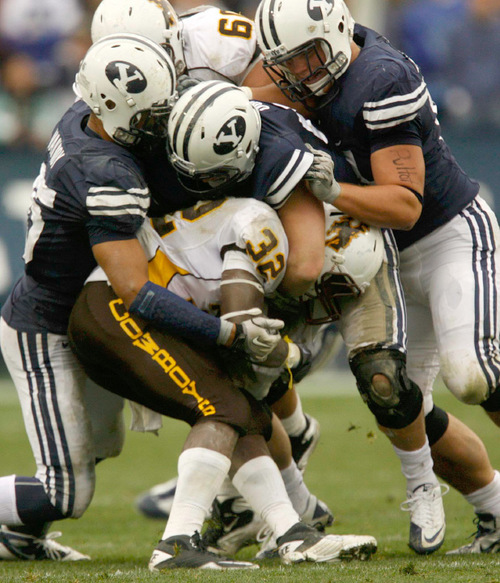 Trent Nelson  |  The Salt Lake Tribune&#xA;A trio of BYU defenders bring down Wyoming's Alvester Alexander during the second half, BYU vs. Wyoming, college football Saturday, October 23, 2010 at LaVell Edwards Stadium in Provo. BYU won 25-20.