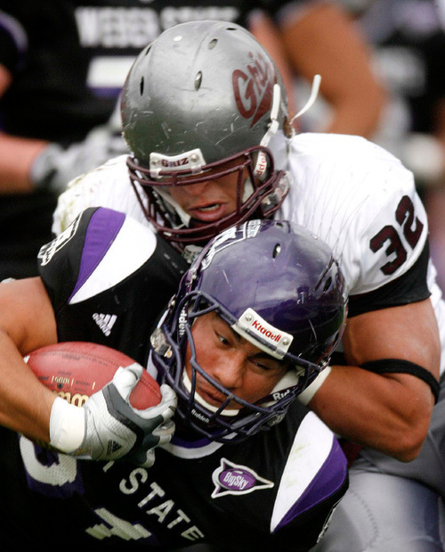 Trent Nelson  |  The Salt Lake Tribune&#xA;Weber State's Vaingamalie Tafuna is brought down by Montana's Alex Shaw in the first half with Montana's Erik Stoll hanging on, Weber State vs. Montana, college football Saturday, October 30, 2010.