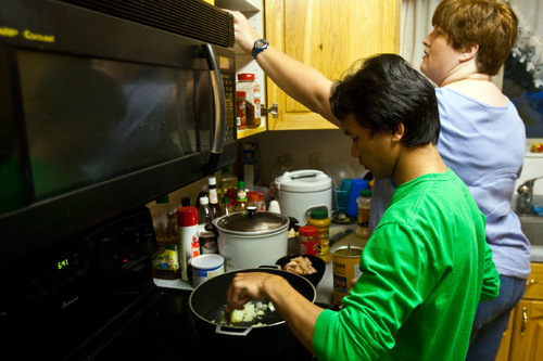 Chris Detrick  |  The Salt Lake Tribune &#xA;Kap Tung, 17, and Sarah Osborn make chicken curry for dinner at their home in West Valley City on Thursday. Nov. 4, 2010. Sarah and Ray Osborn are foster parents to three refugee boys from Myanmar. They also have an adopted daughter. The family is being honored by Catholic Community Services at a Nov. 10 banquet.